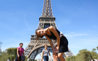 Ellen posing and laughing at the Eiffel Tower in Paris, France for Ellen Blazer's travel blog To Travel and Bloom
